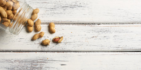 spilled peanuts from a jar on vintage wooden table