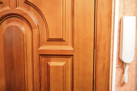 Entrance, wooden door with intercom handset for communicationの写真素材