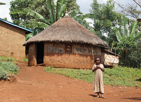 Yirgalem, ETHIOPIA - November 22, 2014: Young girl in front of a typical house of Sidama people on November 22, 2014 in Yirgalem, Ethiopia.のeditorial素材