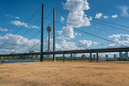 DUESSELDORF, GERMANY - AUGUST 10, 2018: Drought in Germany, low water of the Rhine river in Duesseldorf with bridge and TV tower on August 10, 2018 in Germanyのeditorial素材