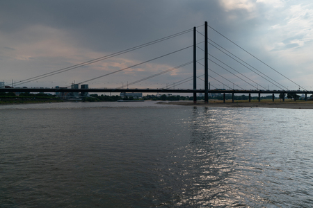 DUESSELDORF, GERMANY - JULY 21, 2018: Panoramic view to a modern bridge over the river Rhine close to Duesseldorf at sundown on July 21, 2018 in Germanyのeditorial素材
