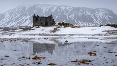 Old farmhouse in front of a mountain, andscape along the southern coast of Iceland at wintertimeの写真素材