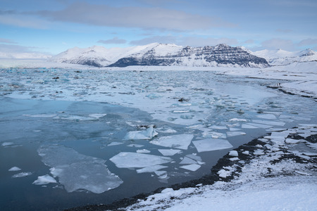 Panoramic view of the glacier lagoon Joekulsarlon with icebergs and in the background the glacier,...