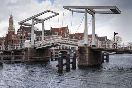 HAARLEM, NETHERLANDS - APRIL 13, 2019: City center with old bridge crossing a creek on April 13, 2019 in Haarlem, Netherlandsのeditorial素材
