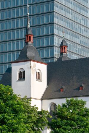 Old church and monastery St. Heribert in front of a modern office building, Cologne, Germanyの写真素材