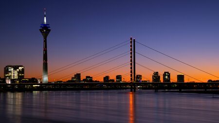 Colorful sunset on the Rhine river with the cityscape of Dusseldorf in the background, Germanyの写真素材