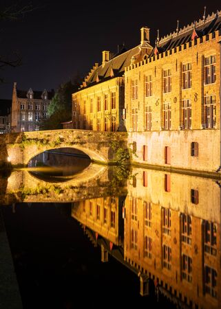 Evening mood with illuminated buildings in the historic city of Bruges, Belgiumの写真素材