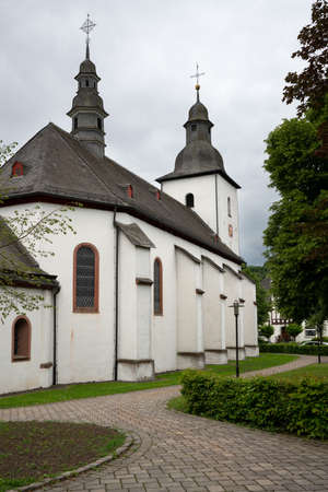 View along a footpath to the parish church of the Sauerland village Oberkirchen, Schmallenberg, Germanyの写真素材