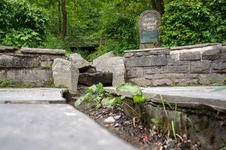 Spring of the river Ruhr with memorial stone and surrounded by trees, Winterberg, Sauerland, Germanyの写真素材