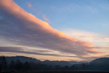 Early morning landscape with pastel-colored cloudsの写真素材