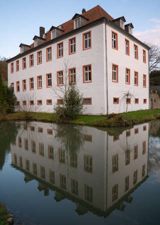 Castle Georghausen close to Lindlar with water reflection at evening hours, Bergisches Land, Germanyのeditorial素材