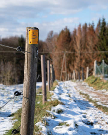 ODENTHAL, GERMANY - FEBRUARY 12, 2021: Long distance hiking trail Bergischer Weg during winter with focus on the typical waymark on February 10, 2021 in Germanyのeditorial素材