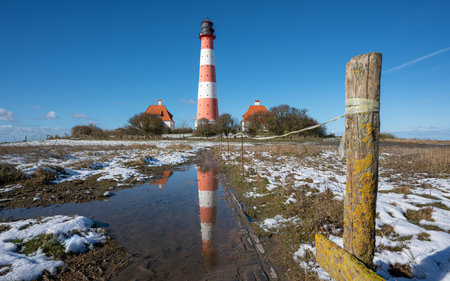 Panoramic image of Westerhever lighthouse during wintertime, North Frisia, Germanyの写真素材