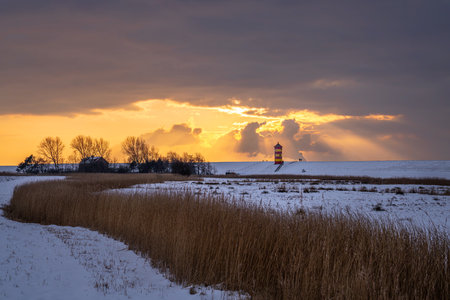 Pilsum, Germany - February 13, 2025: Lighthouse of Pilsum during sunset on February 13, 2025 in East...