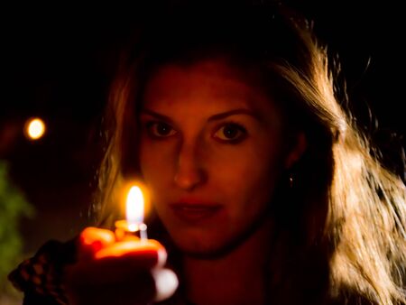 blond woman light the candleの写真素材
