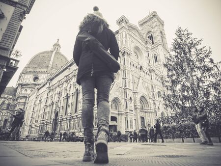 florence italy woman walking towards the Cathedral with backpack at Christmasの写真素材