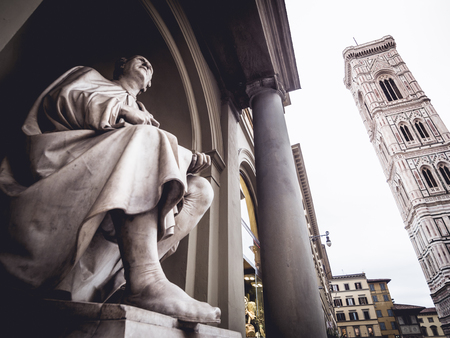 Italy Florence Statue of Filippo Brunelleschi and Giotto's bell tower from belowの写真素材