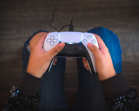 A young woman is holding a game controller, playing video games