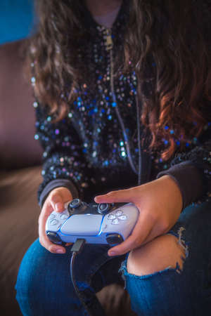 A young woman is holding a game controller, playing video games