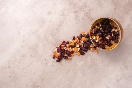 View of a bowl with almonds and blueberries, they fall out of the bowl on the table a very artistic view with room for text. Nuts collection in wooden bowlの写真素材