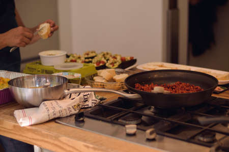 View in a kitchen preparing a plate with fried meat and rolls with toppings and avocadosの写真素材