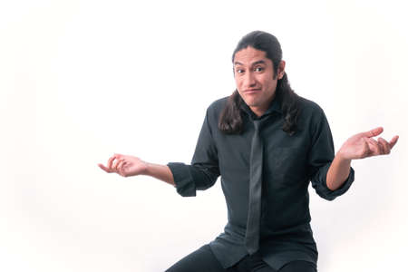 Man on white background. He does not know the answer and makes a gesture with his hands in frustration. dressed in formal clothes. White space. Man gesticulating.の写真素材