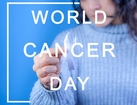 Woman with white ribbon in hand for the month of November: lung cancer awareness month, democracy and international day of peace. Health concept, Text with the legend: "world cancer day".の写真素材