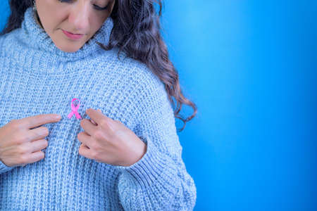 October Breast Cancer Awareness Month, Adult woman holding the Pink Ribbon to support people living with the disease. International Women's Day Concept. Space for textの写真素材