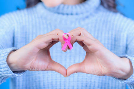 October Breast Cancer Awareness Month, Adult woman holding the Pink Ribbon to support people living with the disease. International Women's Day Concept, Space for textの写真素材