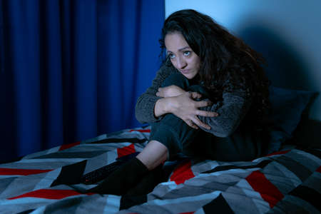 Insomnia, Depressed woman sitting up in bed at night, she can't sleep from insomnia