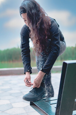 Sneakers. close up of a woman tying shoelaces. Women's sneaker ready for outdoor running in the park...