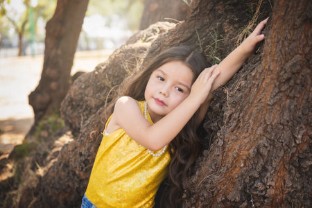 Expressions of happiness, beautiful blonde girl lying on a tree, model girl. children's day theme.の写真素材