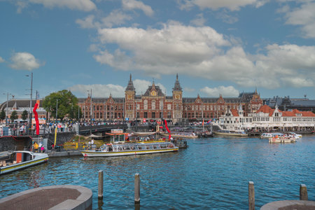 August 20, 2025, Amsterdam, Netherlands, walking through the streets with Amsterdam Central Station in the background on a hot summer day.の写真素材