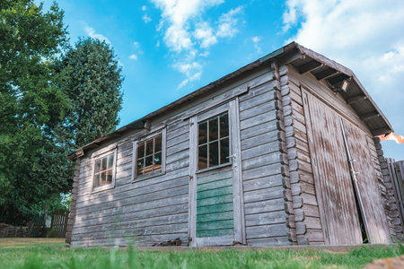 Old cabin or antique wooden barn with vintage texture built at the back of a European house