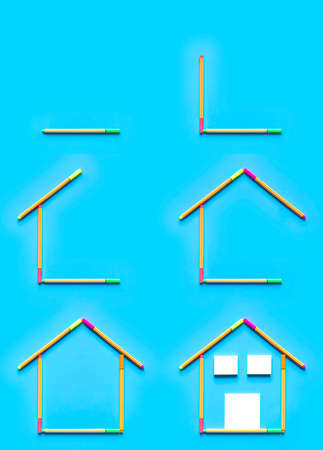 Top view of sticky notes and fluorescent marker pens forming a drawing of a house on pastel blue background, space for text. Construction and housing concept.の写真素材
