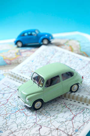 Two miniature classic cars driving through a road map. Space for text. Concept of travel and tourism by car.の写真素材