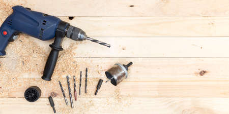 Top view of drill, drill bits and joinery accessories on natural pine wood workbench. Space for text. Work and DIY concept.の写真素材