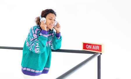 Brunette woman smiling and listening to music in her headphones. She is isolated on a white...