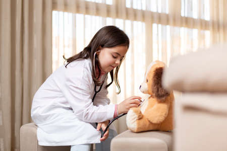 Little child playing at home at the doctors. Space for text.の写真素材