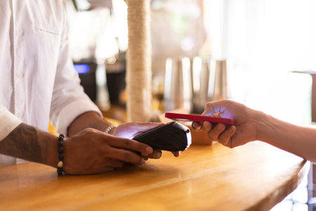 Close up of two people making a contactless payment. Space for text.の写真素材