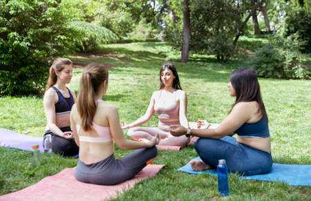 Four young girls doing meditation exercises during outdoor yoga class.の写真素材