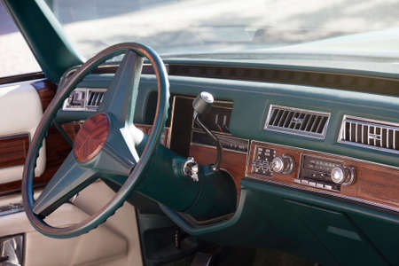 Steering wheel, dashboard and interior of an American classic car. Close-up shot.