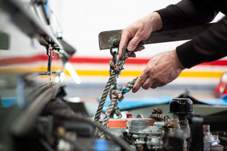 Detail of the hands of a mechanic repairing a car. Unrecognizable person working in a workshop.の写真素材