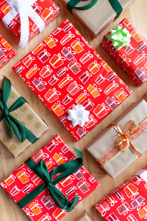 Top view of different gift boxes wrapped with ribbons and bows on wooden background.