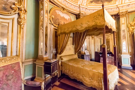 Queluz, Portugal - December 9, 2017: Bedroom inside of rich decorated Queluz Royal Palace. Formerly used as the Summer residence by the Portuguese royal family.のeditorial素材