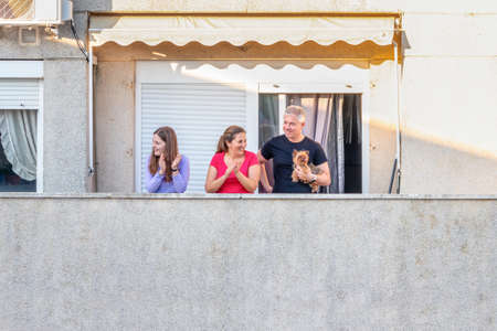 Huelva, Spain - April 7, 2020: Citizens staying at home and clapping everyday on balconies  at 8 PM...