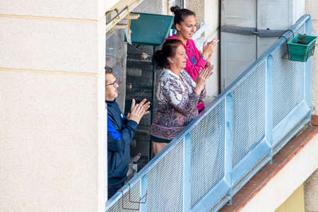 Huelva, Spain - April 10, 2020: Citizens staying at home and clapping everyday on balconies  at 8 PM during the epidemic period of deadly coronavirus. People in quarantine in Spainのeditorial素材