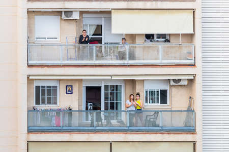 Huelva, Spain - April 27, 2020: Citizens staying at home and clapping everyday on balconies  at 8 PM during the epidemic period of deadly coronavirus. People in quarantine in Spainのeditorial素材