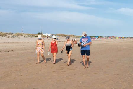 Punta Umbria, Huelva, Spain - May 30, 2020: People walking by the beach wearing protective or medical face masks during the alarm state and quarantine in Spain.のeditorial素材