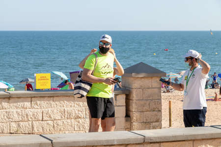 Huelva, Spain - July 4, 2020: People are enjoying at afternoon of Islantilla beachのeditorial素材